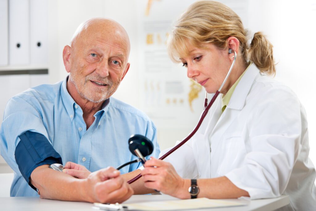Female doctor measuring blood pressure of senior man